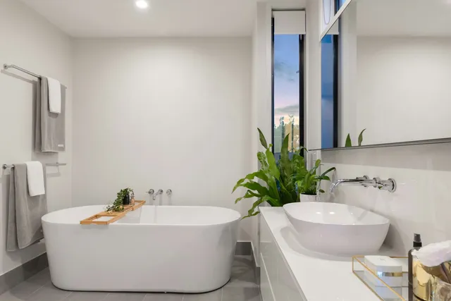 Freestanding tub with marble tub deck and tiled wall
